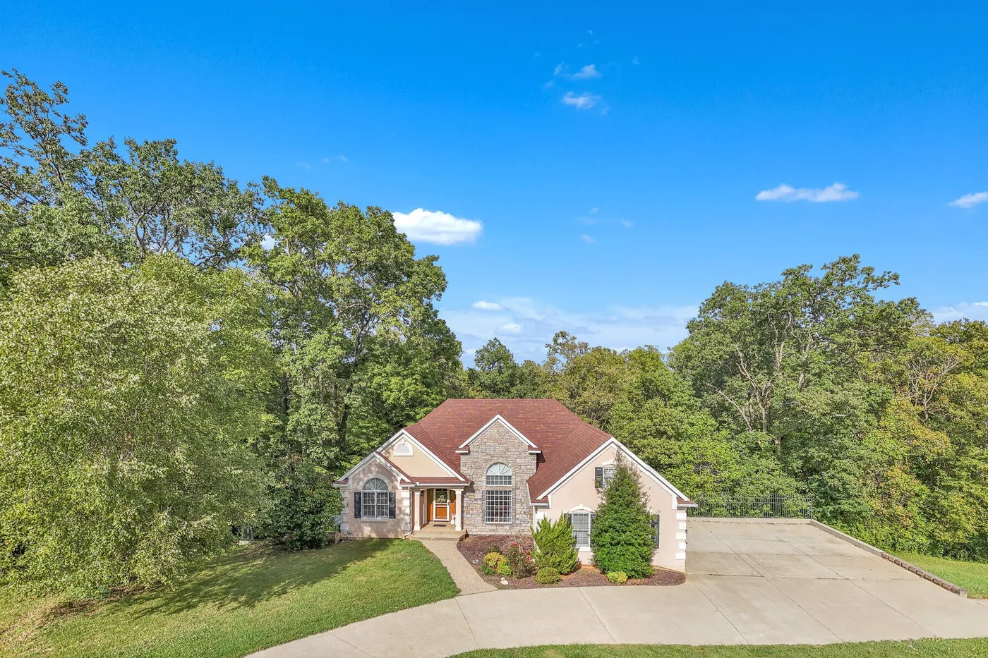 Stone and stucco Kentucky home on a wooded lot